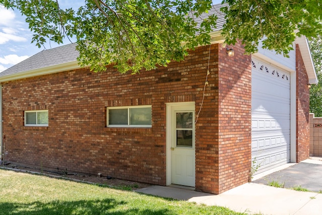 4163 S Beeman Rd, Moab, UT 84532 - view of front facade with brick siding, a garage, driveway, and roof with shingles