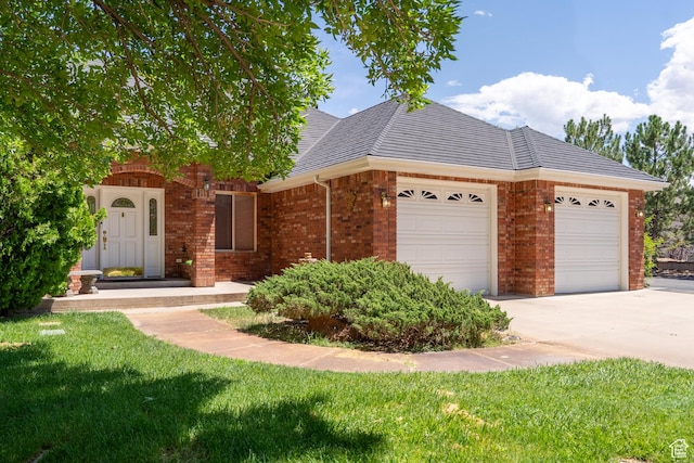 4163 S Beeman Rd, Moab, UT 84532 - view of front of home with a garage, brick siding, driveway, and a front yard
