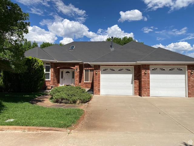 4163 S Beeman Rd, Moab, UT 84532 - view of front of house with an attached garage, driveway, brick siding, and a front yard
