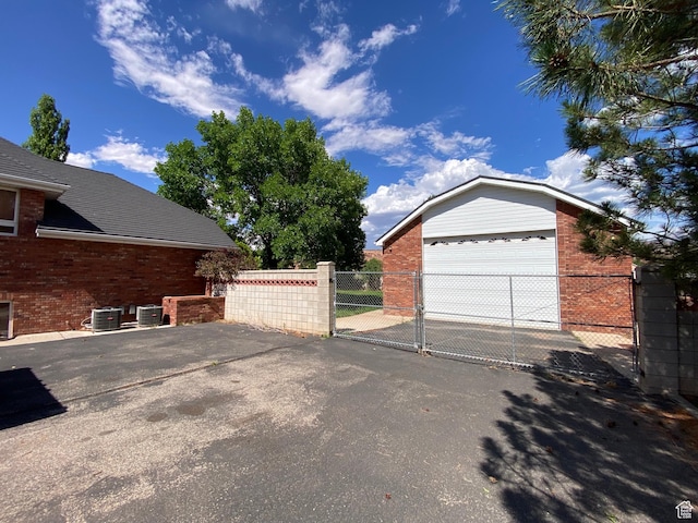 4163 S Beeman Rd, Moab, UT 84532 - view of side of property with brick siding, a gate, a garage, and an outdoor structure