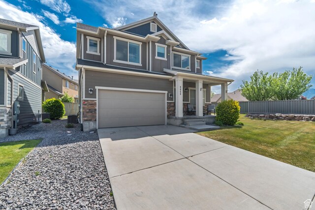 8069 N Quarter Mile Dr, Eagle Mountain, UT 84005 - view of front of home featuring an attached garage, driveway, stone siding, board and batten siding, and covered porch