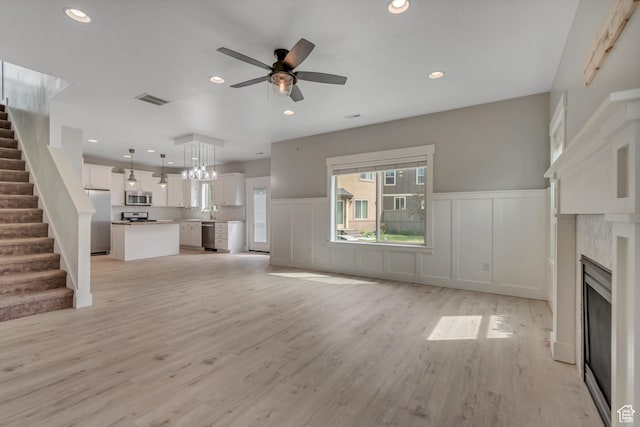 8069 N Quarter Mile Dr, Eagle Mountain, UT 84005 - unfurnished living room featuring a decorative wall, a ceiling fan, stairway, healthy amount of natural light, and recessed lighting