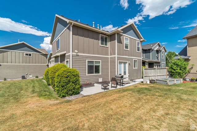8069 N Quarter Mile Dr, Eagle Mountain, UT 84005 - rear view of property featuring board and batten siding, a patio, a lawn, and a vegetable garden