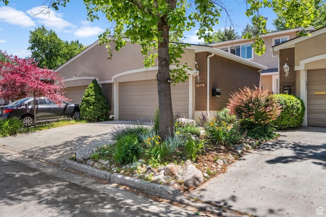 1870 E Monterey Dr, Salt Lake City, UT 84121 - view of front of property with an attached garage, driveway, stucco siding, and brick siding