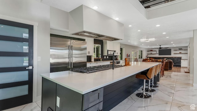 2550 W Lolene Cir, Taylorsville, UT 84129 - kitchen featuring built in refrigerator, light marble finish floors, recessed lighting, white cabinetry, and a spacious island
