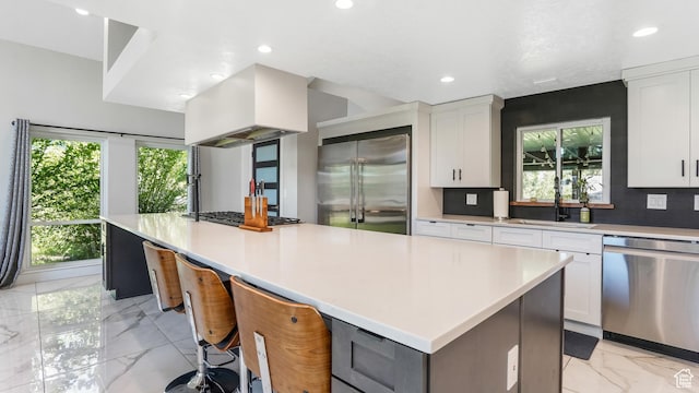 2550 W Lolene Cir, Taylorsville, UT 84129 - kitchen featuring appliances with stainless steel finishes, light marble finish floors, premium range hood, a large island, and recessed lighting