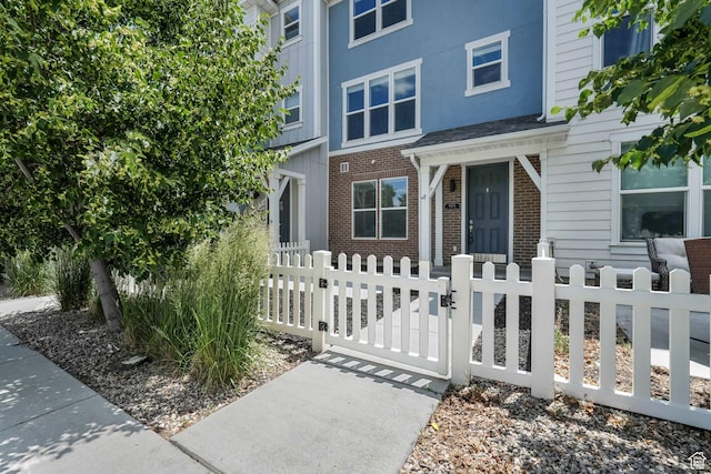 5124 W Stockfield Ln, Herriman, UT 84096 - view of front facade featuring a gate, a fenced front yard, and brick siding