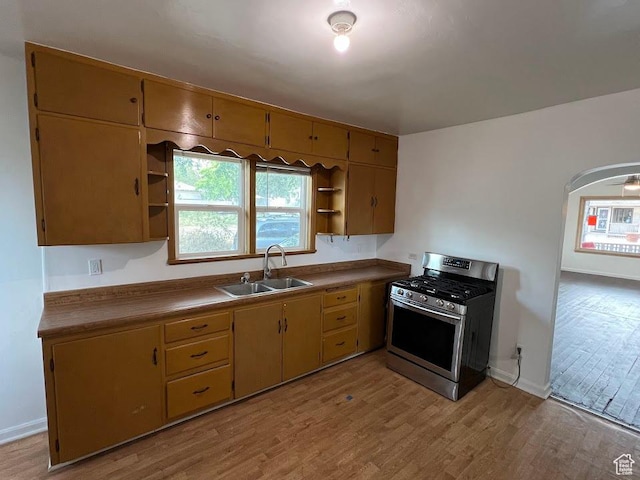 2859 S 9000 W, Magna, UT 84044 - kitchen with stainless steel range with gas stovetop, open shelves, light wood finished floors, and arched walkways