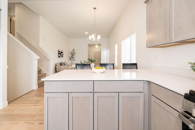425 W Domain Ln, Grantsville, UT 84029 - kitchen featuring a peninsula, light countertops, light wood finished floors, a chandelier, and open floor plan