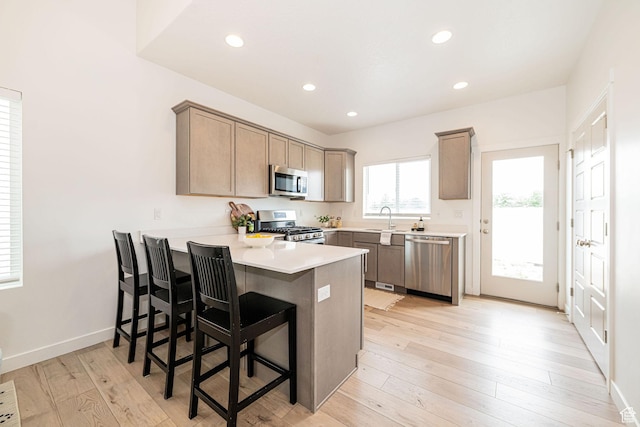 425 W Domain Ln, Grantsville, UT 84029 - kitchen with stainless steel appliances, a peninsula, recessed lighting, light countertops, and a breakfast bar area