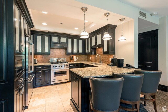 2100 W Frostwood Blvd Unit 4175, Park City, UT 84098 - kitchen featuring appliances with stainless steel finishes, under cabinet range hood, a peninsula, tasteful backsplash, and a breakfast bar