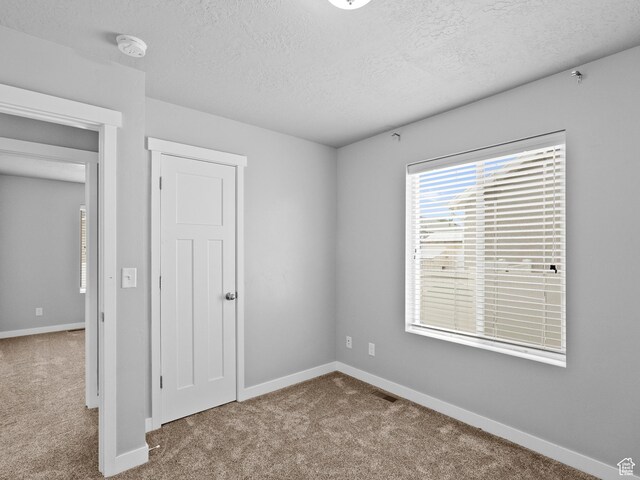 517 E 1140 S, Roosevelt, UT 84066 - unfurnished bedroom featuring carpet floors and a textured ceiling