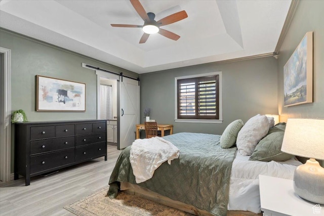 1025 N Apple Seed Ln, Santaquin, UT 84655 - bedroom with a barn door, light wood-type flooring, a tray ceiling, ornamental molding, and ceiling fan