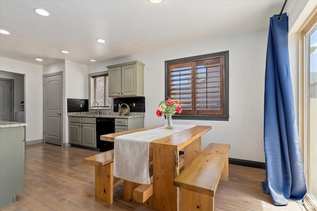 1025 N Apple Seed Ln, Santaquin, UT 84655 - kitchen featuring light wood-style flooring, black dishwasher, healthy amount of natural light, recessed lighting, and decorative backsplash