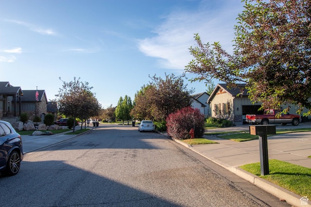 5818 N Cambridge Dr E, Mountain Green, UT 84050 - view of asphalt road featuring curbs, a residential view, and sidewalks