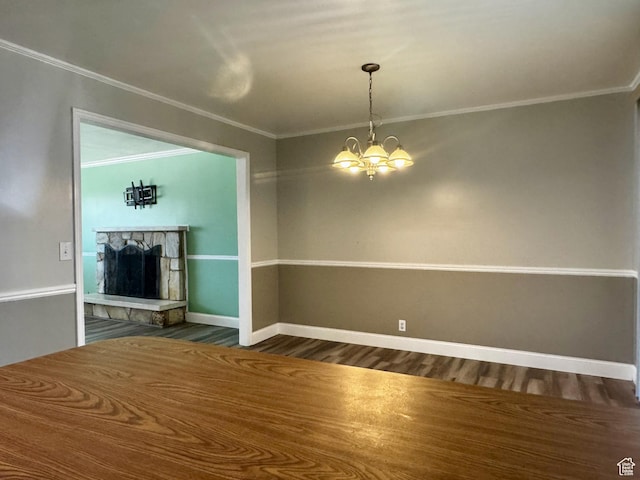 7026 S Wood Green Rd, West Jordan, UT 84084 - unfurnished living room with crown molding, dark wood-style floors, a chandelier, and a stone fireplace