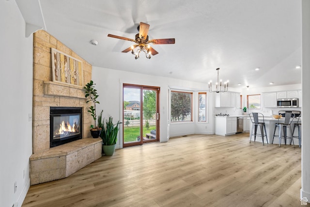 4212 N Majors St E, Eagle Mountain, UT 84005 - unfurnished living room featuring lofted ceiling, a fireplace, a chandelier, light wood-style floors, and a ceiling fan