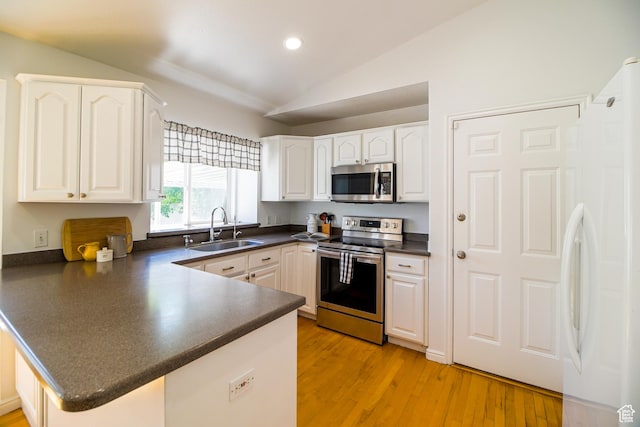 1536 N 150 W, Bountiful, UT 84010 - kitchen with stainless steel appliances, dark countertops, a peninsula, vaulted ceiling, and white cabinets