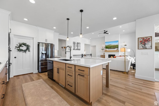 10243 S Dial Ct, South Jordan, UT 84009 - kitchen featuring a glass covered fireplace, stainless steel fridge, light wood-style flooring, a breakfast bar area, and light countertops