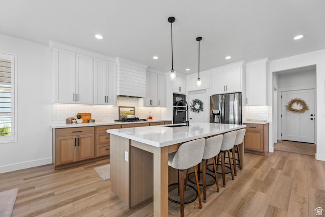 10243 S Dial Ct, South Jordan, UT 84009 - kitchen with appliances with stainless steel finishes, light wood finished floors, tasteful backsplash, light countertops, and recessed lighting