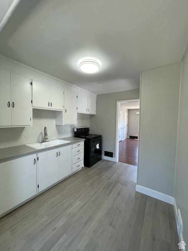 1783 N 300 W, Sunset, UT 84015 - kitchen with black electric range oven, light wood-type flooring, white cabinets, and light countertops