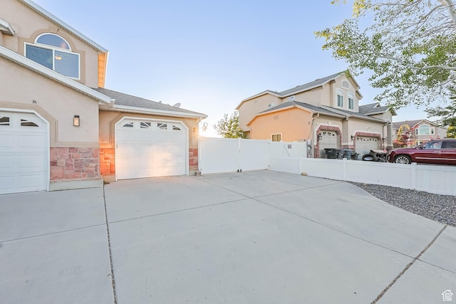 10314 S 3970 W, South Jordan, UT 84009 - view of side of property with driveway, stucco siding, a garage, and stone siding