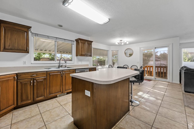 10314 S 3970 W, South Jordan, UT 84009 - kitchen featuring light countertops, a textured ceiling, plenty of natural light, light tile patterned floors, and a breakfast bar