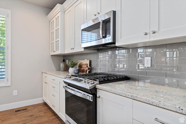 12140 S Galena Grove Way W, Draper, UT 84020 - kitchen featuring stainless steel appliances, decorative backsplash, light wood-style floors, white cabinetry, and light stone counters