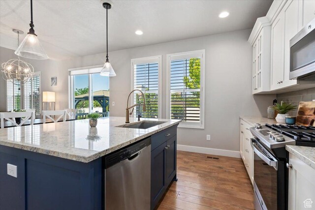 12140 S Galena Grove Way W, Draper, UT 84020 - kitchen with stainless steel appliances, hardwood / wood-style flooring, white cabinetry, a kitchen island with sink, and recessed lighting