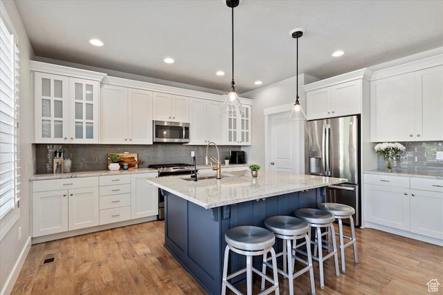 12140 S Galena Grove Way W, Draper, UT 84020 - kitchen featuring appliances with stainless steel finishes, decorative backsplash, light wood-style floors, white cabinets, and recessed lighting