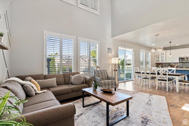 12140 S Galena Grove Way W, Draper, UT 84020 - living room featuring a chandelier, light wood-type flooring, and a high ceiling