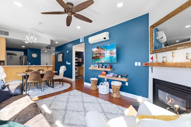6785 N 2200 W Unit 207, Park City, UT 84098 - living room with wood finished floors, a chandelier, a wall mounted air conditioner, ceiling fan, and a glass covered fireplace