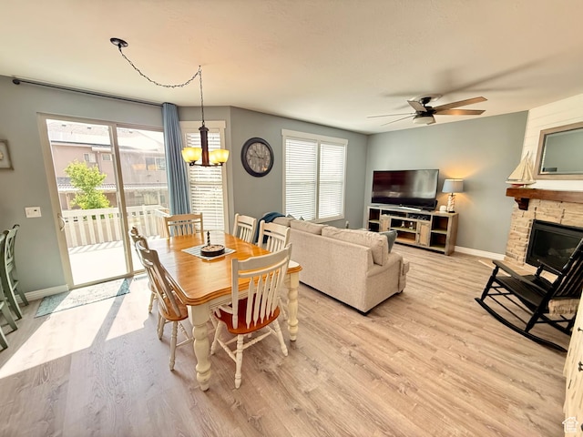 12887 S Wild Mare Way, Riverton, UT 84096 - dining space with a ceiling fan, light wood-type flooring, a chandelier, and a fireplace