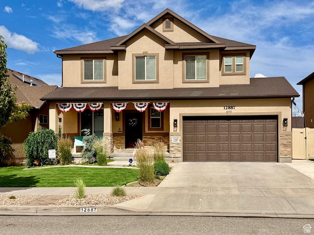 12887 S Wild Mare Way, Riverton, UT 84096 - view of front facade featuring stucco siding, driveway, a front yard, a garage, and stone siding