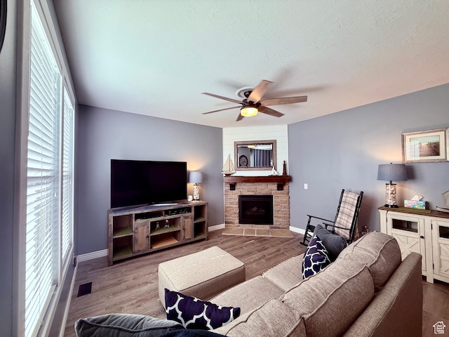 12887 S Wild Mare Way, Riverton, UT 84096 - living area featuring a ceiling fan, a stone fireplace, wood finished floors, and a textured ceiling