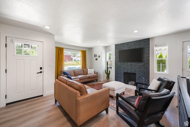 2500 E Simpson Ave S, Salt Lake City, UT 84109 - living room featuring light wood-style flooring, a fireplace, a textured ceiling, and recessed lighting