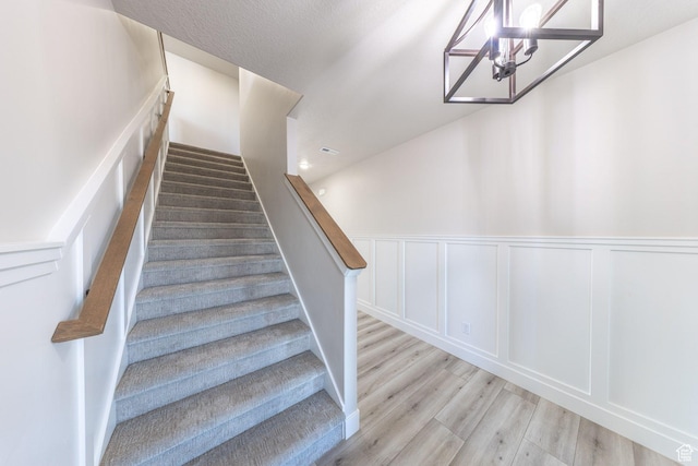 2864 N 3475 W, Plain City, UT 84404 - stairs featuring wood finished floors, a chandelier, wainscoting, and a decorative wall