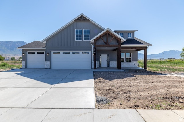 2864 N 3475 W, Plain City, UT 84404 - view of front of home featuring a mountain view, driveway, covered porch, board and batten siding, and a garage
