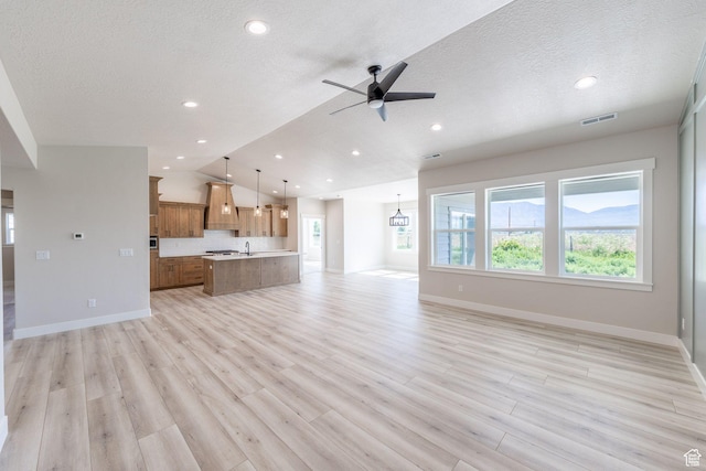 2864 N 3475 W, Plain City, UT 84404 - unfurnished living room with vaulted ceiling, ceiling fan, light wood-style flooring, a textured ceiling, and recessed lighting