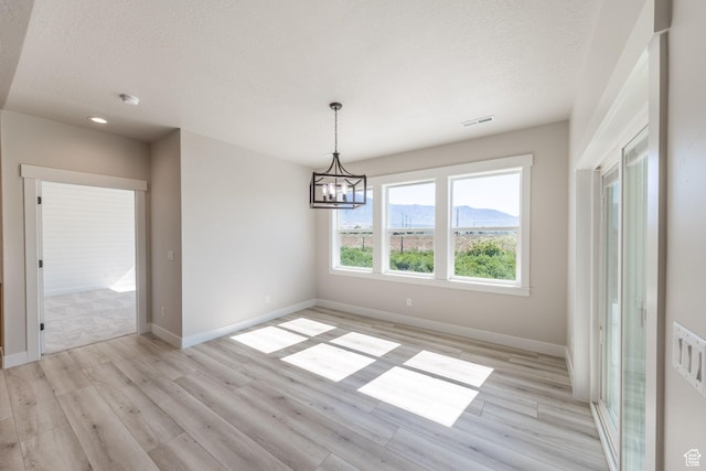 2864 N 3475 W, Plain City, UT 84404 - unfurnished dining area with light wood-style flooring, a chandelier, and a textured ceiling
