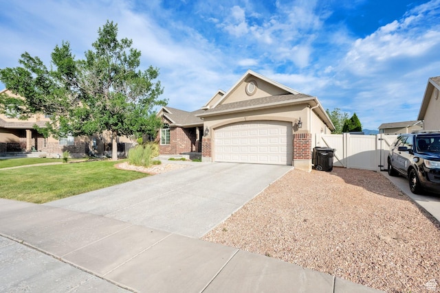 356 Warley Way, Stansbury Park, UT 84074 - ranch-style house featuring concrete driveway, a garage, brick siding, and a gate