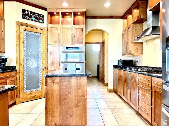620 S Michael St, Vernal, UT 84078 - kitchen with wall chimney range hood, arched walkways, stainless steel appliances, a kitchen island, and light tile patterned floors