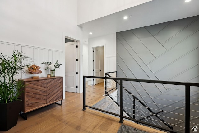 8960 Parleys Ln, Park City, UT 84098 - hallway with a decorative wall, wood finished floors, an upstairs landing, a high ceiling, and recessed lighting