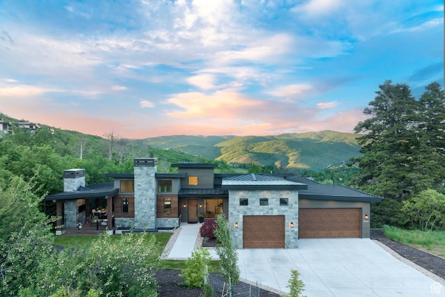 8960 Parleys Ln, Park City, UT 84098 - contemporary home with stone siding, a garage, a standing seam roof, and a chimney