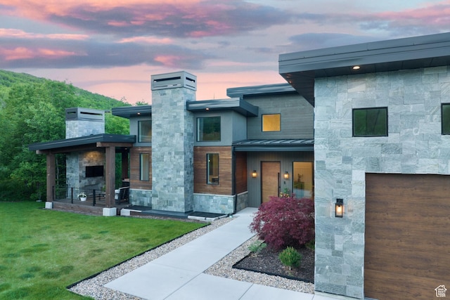 8960 Parleys Ln, Park City, UT 84098 - contemporary home with a standing seam roof, a chimney, stone siding, a yard, and a metal roof