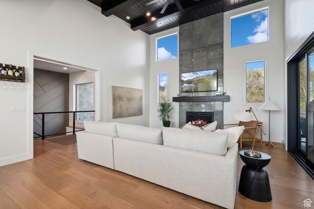 8960 Parleys Ln, Park City, UT 84098 - living area with a towering ceiling, wood finished floors, a tile fireplace, plenty of natural light, and a wooden ceiling with exposed beams