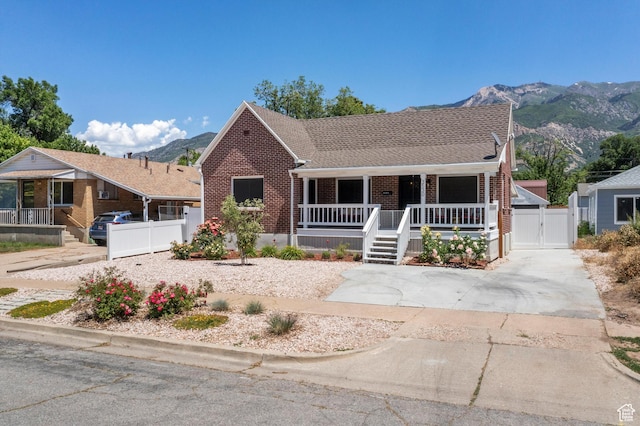 3530 Madison Ave, Ogden, UT 84403 - view of front facade with a gate, brick siding, a porch, and a mountain view