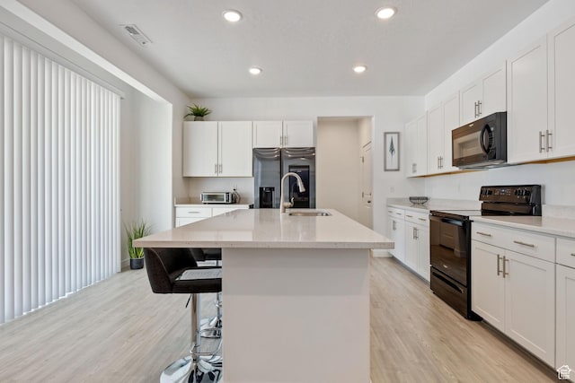 743 W 950 S, Springville, UT 84663 - kitchen featuring black appliances, light wood-style floors, a kitchen island with sink, white cabinetry, and recessed lighting