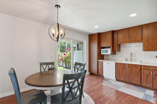 435 E 2100 N, North Ogden, UT 84414 - kitchen with white appliances, dark wood-style flooring, light countertops, brown cabinetry, and a chandelier