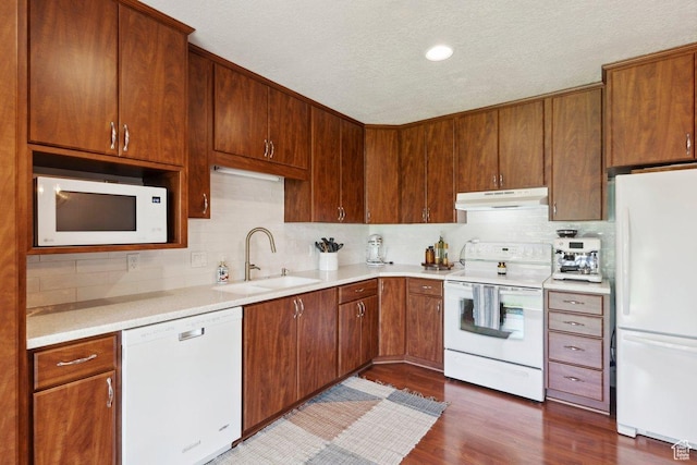 435 E 2100 N, North Ogden, UT 84414 - kitchen featuring white appliances, under cabinet range hood, backsplash, light countertops, and dark wood-type flooring